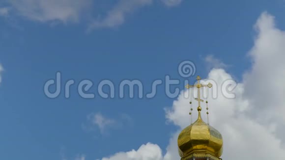 蓝天白云背景下的东正教寺庙的金色穹顶寺庙穹顶上的金色十字架时间流逝视频的预览图