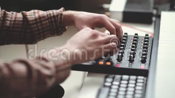 现代作曲家写电子音乐在面板后面工作视频的预览图