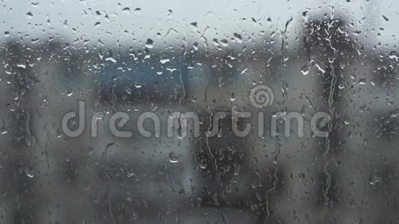 窗玻璃上的雨滴背景中的建筑物视频的预览图