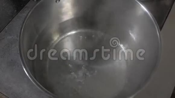 再培训厨房的电炉上锅里烧水在不锈钢锅里视频的预览图