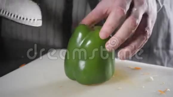 用刀切新鲜蔬菜的手特写年轻的厨师在白色的切割板特写上切割辣椒烹饪视频的预览图