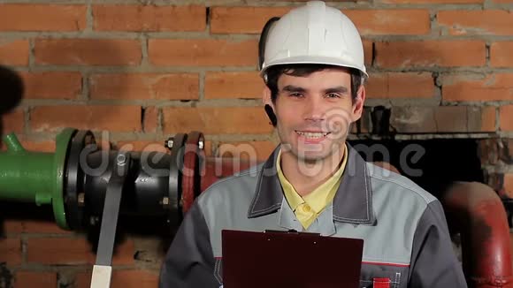 一位英俊的白人男性黑发工程师笑的肖像戴着头盔的工人笑着露出牙齿视频的预览图