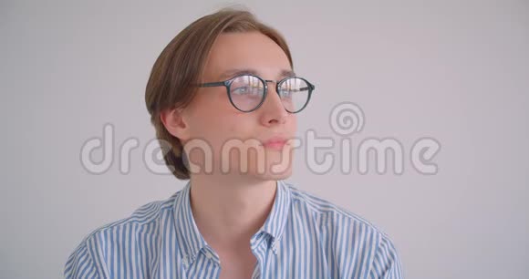 年轻迷人的白种人商人戴着眼镜看着镜头在室内愉快地微笑视频的预览图