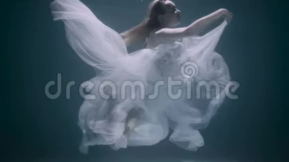 穿着白色连衣裙在水下游泳的年轻女孩视频的预览图