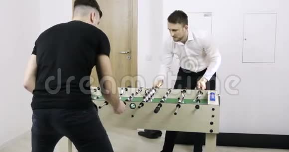 两个年轻人在办公室踢桌球视频的预览图