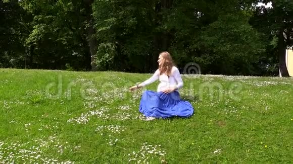 孕妇坐在草地上采菊花视频的预览图
