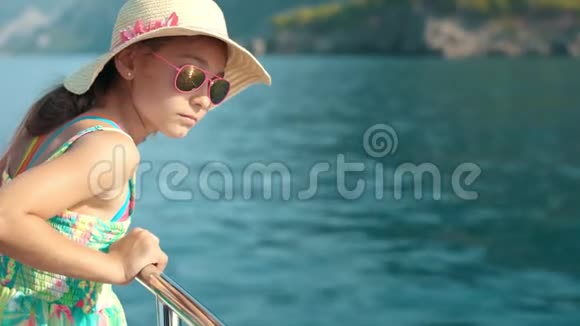 女孩暑假在游艇上旅行从帆船上看水的女孩视频的预览图