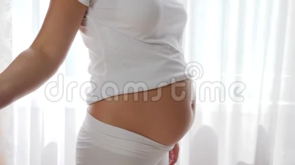 肚子大的孕妇用玻璃矿泉水和裸腹抚摸视频的预览图