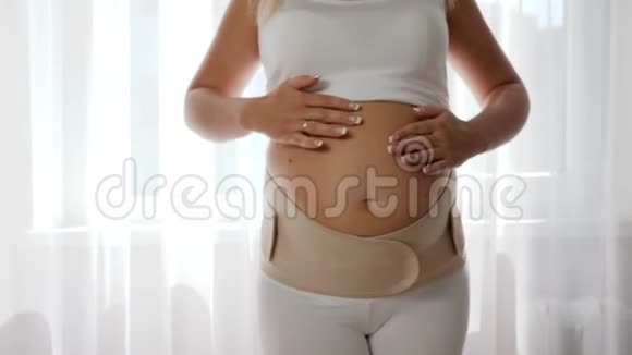 女孩穿上可调节的支架以获得舒适特写为孕妇收紧绷带视频的预览图