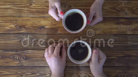 男人和女人手里拿着几杯咖啡放在木桌上喝视频的预览图