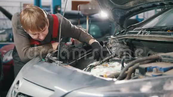 机械师检查汽车发动机汽车修理在车间工作大修罩下视频的预览图
