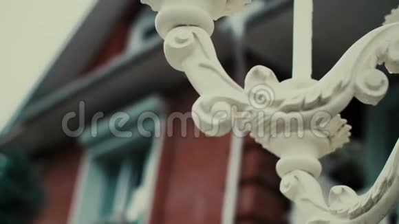 一座白色的喷泉装饰着美丽的雕刻矗立在一座红砖乡村的房子旁边视频的预览图
