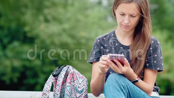 年轻的女人用她的手机视频的预览图