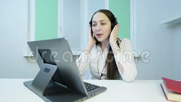 迷人的黑发女人戴着耳机唱着一首令人兴奋和温柔的歌视频的预览图