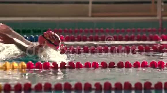 女游泳运动员在游泳池里以蝴蝶的方式游泳慢动作视频的预览图