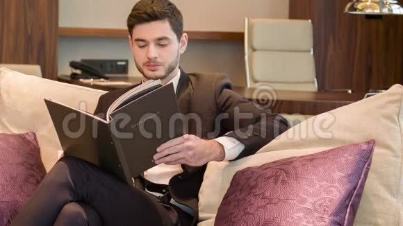愉快的商务小姐坐在他的旅馆房间里视频的预览图