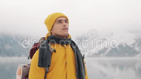 旅行者站在美丽的湖泊附近白雪覆盖的山脉中希克尔看着美丽的大自然视频的预览图