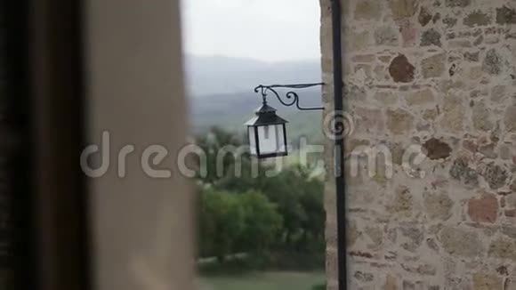 中世纪城堡石壁上的老黑铁灯背景青山视频的预览图