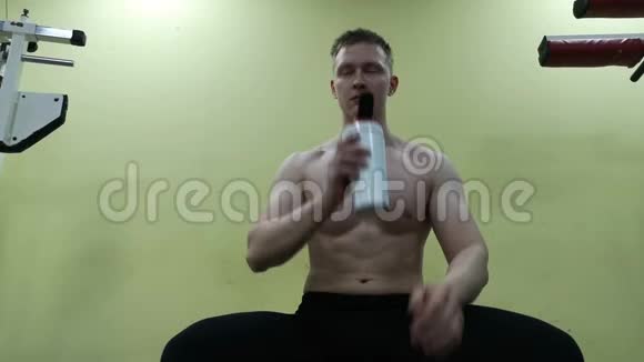 年轻人在健身房喝水他用蛋白奶昔视频的预览图