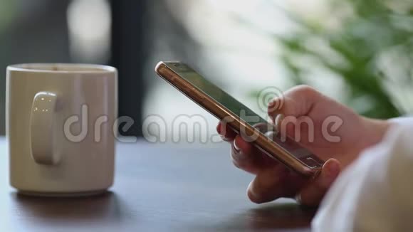 在咖啡休息时女人用手机闭上双手视频的预览图