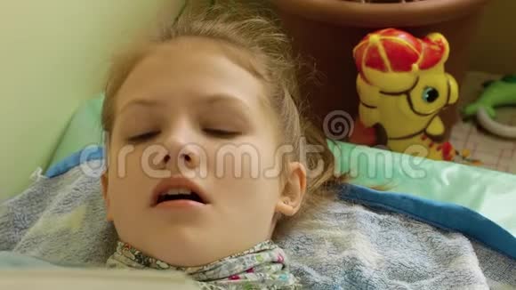 脖子上戴围巾的女孩在床上看书咳嗽视频的预览图