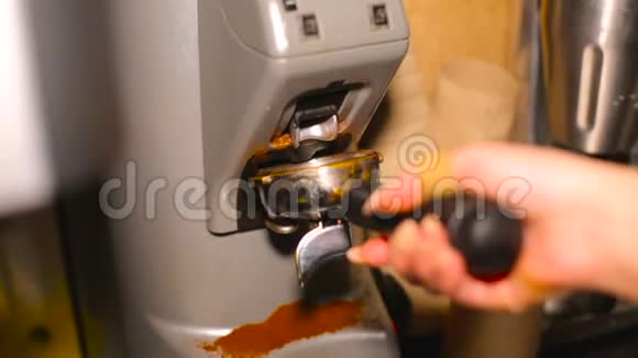 咖啡吧台后面的咖啡研磨机在咖啡架里倒着咖啡视频的预览图