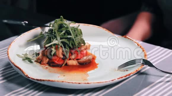 餐馆餐桌上的沙拉用刀叉切肉将女人的手闭上视频的预览图