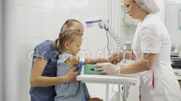 女孩子和母亲坐在一起护士为她抽血做准备视频的预览图