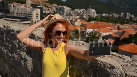 戴眼镜戴帽子的年轻女子在古城背景上自拍视频的预览图