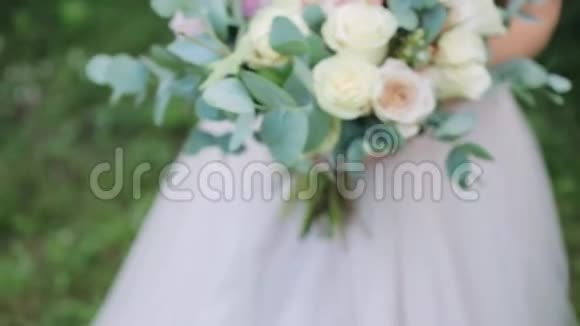 穿着婚纱的年轻女孩拿着新娘的花束特写镜头结婚花束美丽的新娘花束视频的预览图