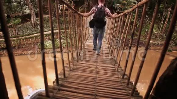 游客走在丛林里用竹子做的吊桥上视频的预览图