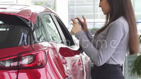 一个女人用她的智能手机站在她的车附近被打了弯视频的预览图