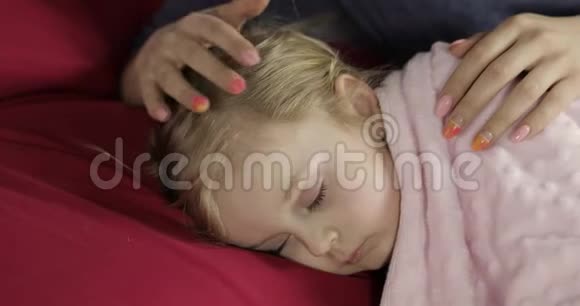 年轻的母亲在睡觉时照顾她的小宝贝女儿上床的女孩视频的预览图