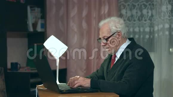 爷爷在家里用笔记本电脑视频的预览图