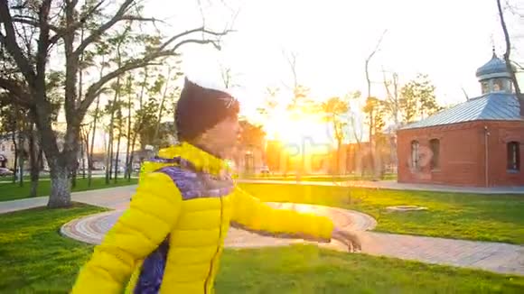 日落时分年轻女孩骑着溜冰鞋在春天公园里视频的预览图