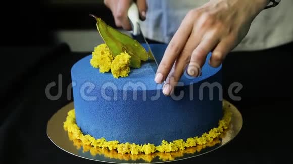 糖果手把蓝色装饰的蛋糕切成两部分视频的预览图