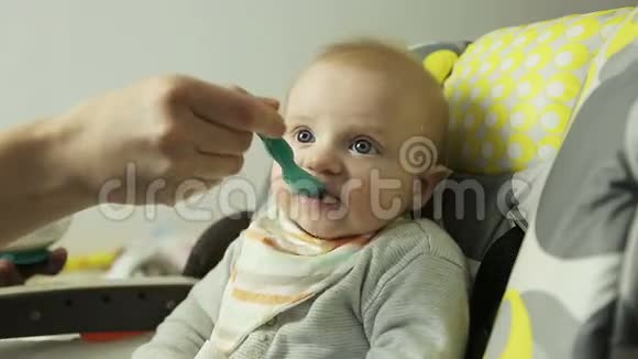 特写镜头妈妈给婴儿喂麦片视频的预览图