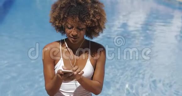 放松的女人在游泳池里享受音乐视频的预览图