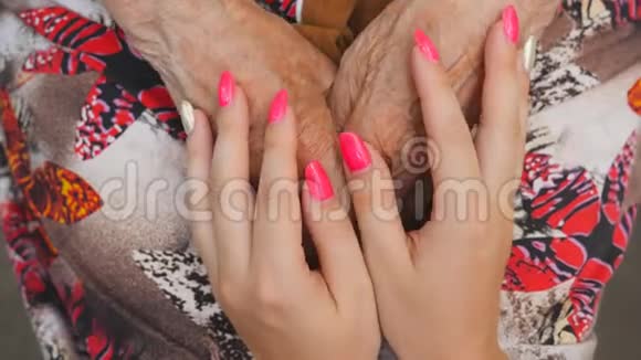 老妇人抚摸着年轻的女性手孙女和祖母一起度过时光关心和爱的概念视频的预览图