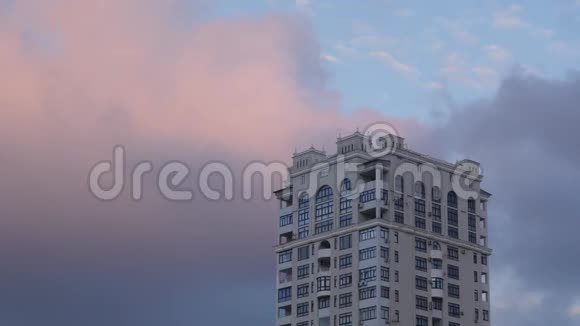 天空背景上的高层建筑日落时有移动的云视频的预览图