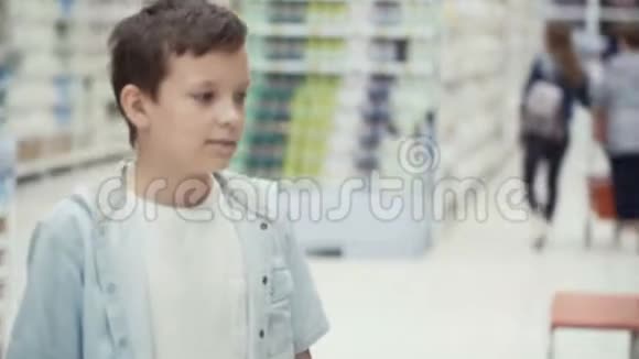 超市里的小男孩选择了一瓶果汁视频的预览图