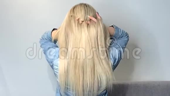 金发女人在美容院接受治疗后挥舞着她美丽健康的头发视频的预览图