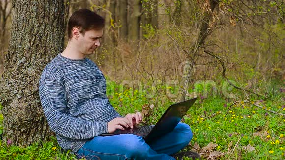 春天男人在花园里的电脑上工作视频的预览图
