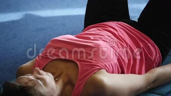 疲惫疲惫的女运动员在健身房地板上视频的预览图