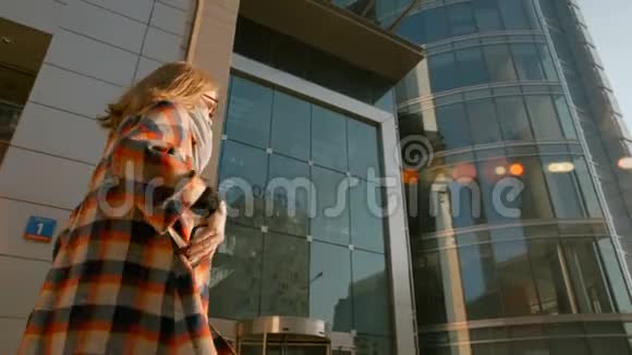 年轻女子走在市中心在她的智能手机上接收信息视频的预览图