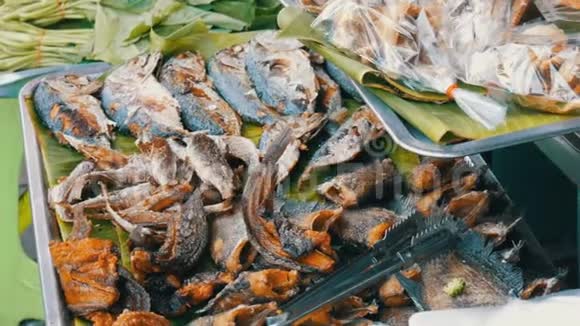 炸鱼躺在香蕉叶上柜台提供各种泰国菜亚洲街头食品视频的预览图