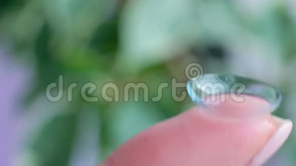 宏在手指上拍摄隐形眼镜绿色背景高清镜头视频的预览图