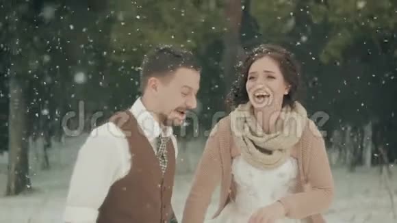 可爱的一对夫妇在冬天的圣诞公园散步下雪了视频的预览图