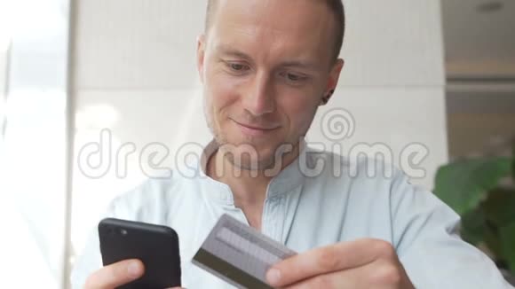 白种人使用手机用信用卡网上购物视频的预览图
