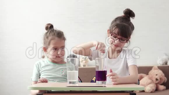 幼儿进行化学实验对化学反应感到惊讶两个小女孩在家玩视频的预览图